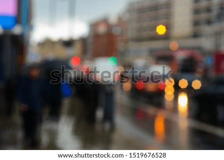 Blurred background of the city lights, silhouettes of people and cars 