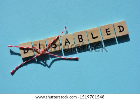 Disabled in wooden alphabet letters with Dis crossed out, leaving the word Abled. Light blue background with copy space