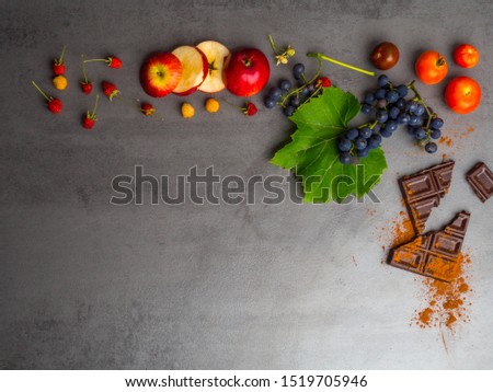 anticancer food, good for cardiovasculas system, fresh ripe grape, dark chocolate, raspberries, tomatoes, apple on concrete background. Food rich in resveratrol, antioxidants, copy space Royalty-Free Stock Photo #1519705946