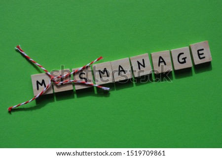 Mismanage in wooden alphabet letters with Mis crossed out, leaving the word Manage. Green background with copy space