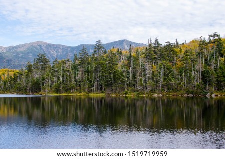 View of lonesome lake by mountains in autumn or fall Royalty-Free Stock Photo #1519719959