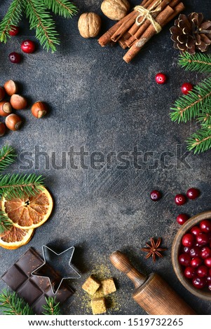Culinary background with christmas winter spices and ingredients for baking on a dark slate, stone or concrete table. Top view with copy space.