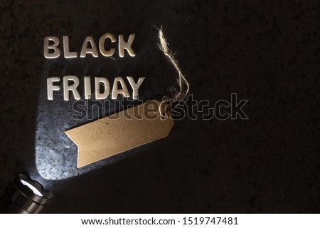 flashlight pointing at Rustic Black friday wooden letters on a zinc finish background