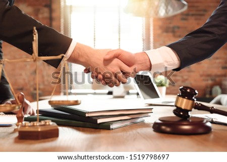 Lawyer and his client handshake. Agreement with attorney in office. Law and justice concept