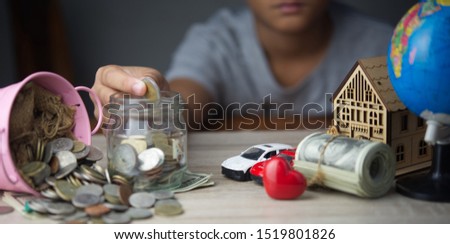 Boy drop money coins to jar. Concept of Insurance money savings for retirement planning .