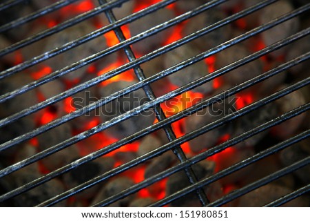 Burning grill with red hot coal with grate over