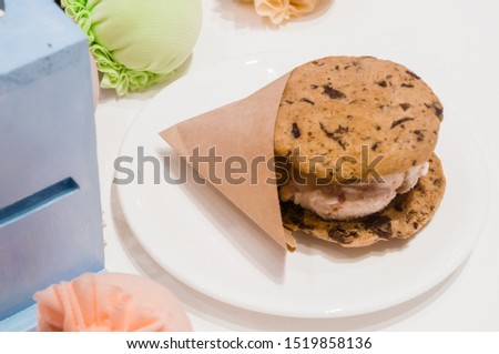 Food photography, top down view closeup picture of an Ice Cream Cookie Sandwiches on a white table with decorative elements and a white plate