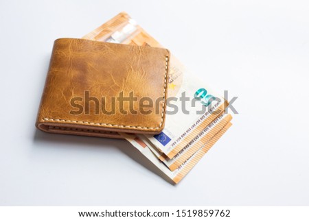 Leather bifold wallet with euro money bill on white background