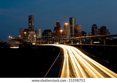 Nighttime traffic out of the city center with skyline and blue sky