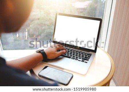 Close up of man using blank cell phone,laptop and credit card sending massages shopping online or reporting lost card, fraudulent transaction within the coffee shop