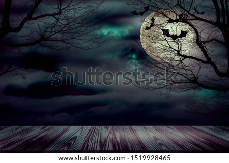 Halloween backdrop with the old grunge plank wood board and the silhouette trees with full moon and flying bats on the mystery dark cloud at night.