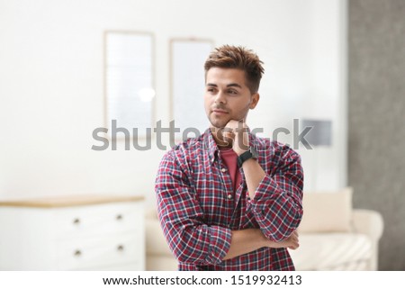 Portrait of handsome young man in room