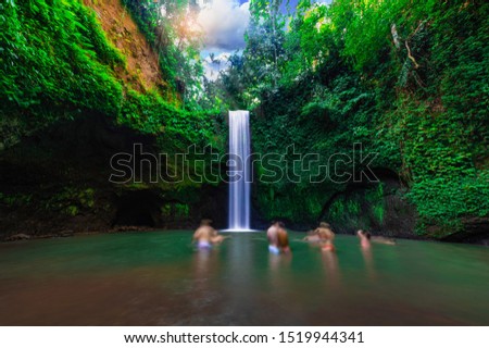 Tourist visits Tibumana waterfall which is famous place & top travel destination in Bali,Indonesia.(Blur the tourist image)