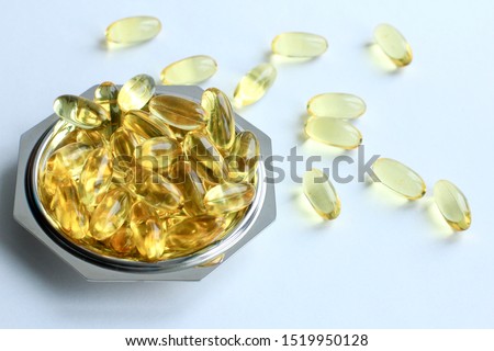 Omega 3 capsules in small gray plate lying on white background. Fish oil in pills. Health support and treatment. Biologically active additives. Color of the year 2021.