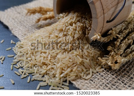 Thai parboiled brown rice in a wooden tray on a black background