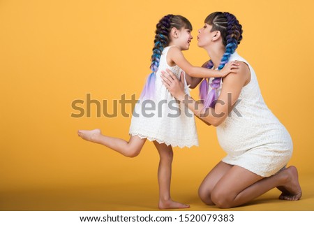 Happy young pregnant mother holds daughter