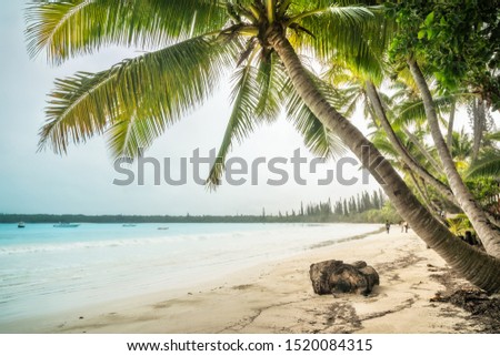 People walking on the beach at Kuto Bay on Isle of Pines in New Caledonia, French Polynesia, South Pacific Ocean.
