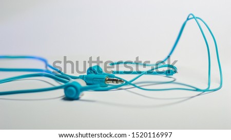 Bright Blue high-tech earbuds with plastic chord on a white background