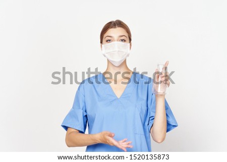 female doctor in medical mask and blue coat holding a bottle in his hand chemistry laboratory