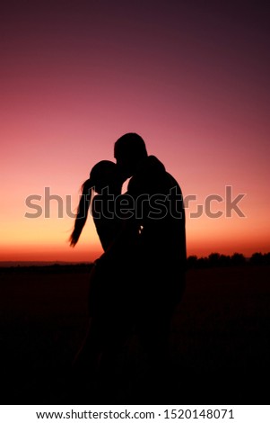 
In the photographs you can see a couple, with the sunset showing their silhouette due to the summer. The couple is kissing.