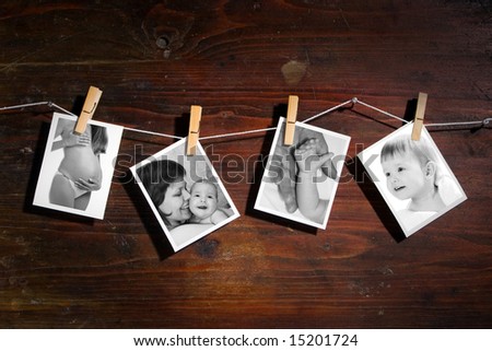 Pictures of a newborn and mother attach to rope with clothes spins on wooden background