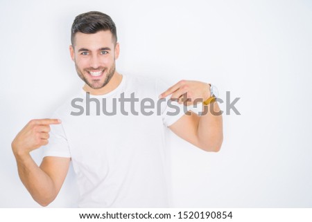 Young handsome man wearing casual white t-shirt over white isolated background looking confident with smile on face, pointing oneself with fingers proud and happy.