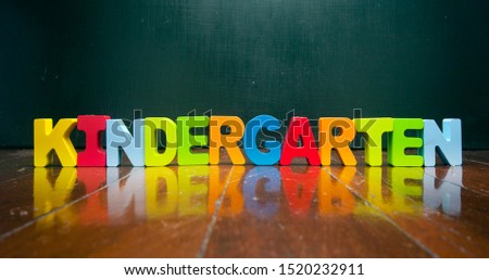 the word KINDERGARTEN with old wooden letters on a wooden floor 