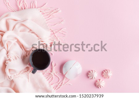 Arrangement of warm scarf, cup of coffee and meringue. Top view and flat lay autumn composition with copy space