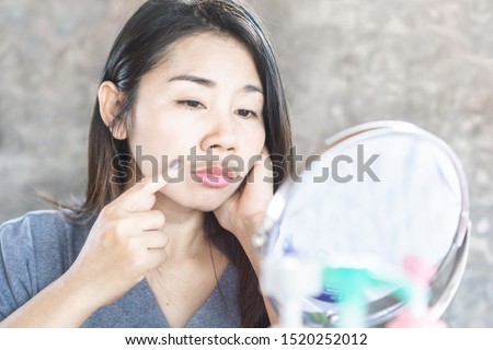 unhappy Asian woman having problem with mustache growing on face 