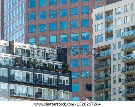 Multi-dwelling modern apartment buildings with  balconies, zoom, close up. Apartments in a strata living scheme of common property in a central business district of a busy city. Royalty-Free Stock Photo #1520267264