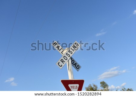 Rural railroad crossing blue sky