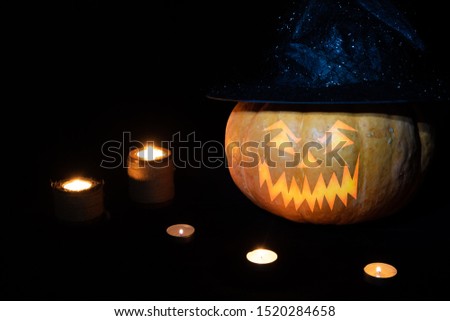 Halloween pumpkin on a black background with candles. Halloween holiday.
