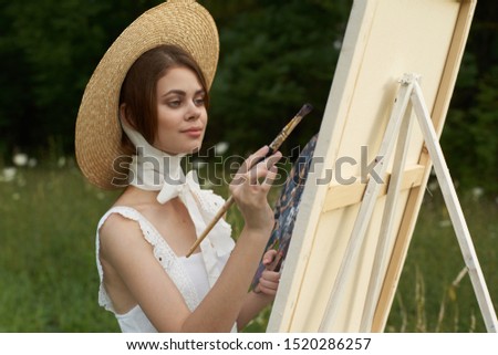 young beautiful woman with a white canvas for painting outdoors