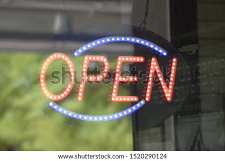 Lighted open neon sign on a business window open for business