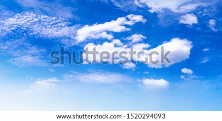 The sky looked bright blue, consisting of a group of small and large white clouds moving along with the wind, floating in the air during the soft sunlight during the morning of the new day.