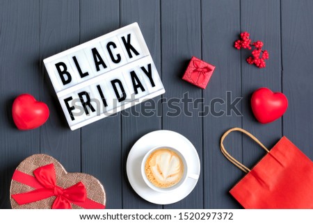 red heart, hot cappuccino coffee, red paper bag, gift box, lightbox with text Black Friday on a dark gray background Top view Flat lay Autumn, october, november, sesonal sale, retail, shopping concept