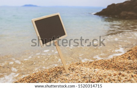 Summer vacation holiday concept. Empty wooden sign board for message on sand beach with seascape in background