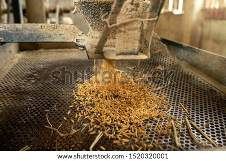 Some part of rice mill machine during working.,Flying rice in the basket