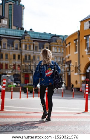 Young beautiful woman walks around the city in Europe, street photo, female posing in the city center