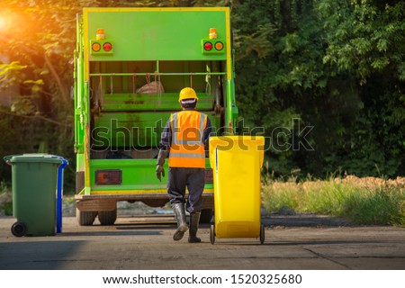 Recyclable garbage truck and the keeper  in the village. Royalty-Free Stock Photo #1520325680