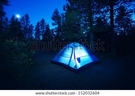 Forest Camping - Small Illuminated Tent at Night. Camping in California Forest, USA. Camping and Outdoor Photo Collection.