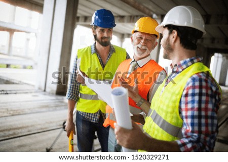 Team of architects and engineer in group on construciton site check documents and business workflow