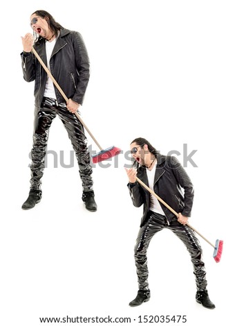 Caucasian man playing broom like guitar against white background.