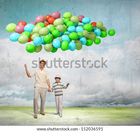 Image of father and son holding bunch of colorful balloons