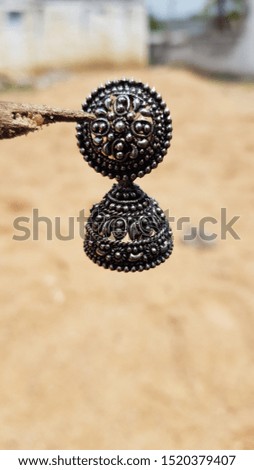 black metal earring with sand background