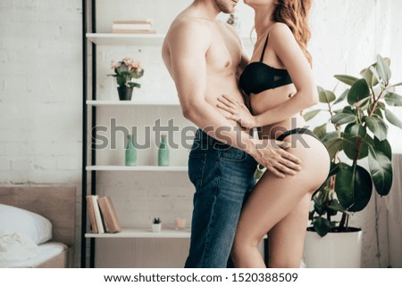 cropped view of boyfriend hugging girlfriend in black underwear 