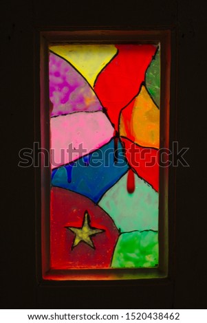 Multi-colored stained-glass windows in an old wooden door. Abstract pattern on glass.