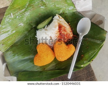 Pictures of banana leaf nasi lemak and two heart-shaped chicken nuggets.Nasi lemak is  traditional malay food. 