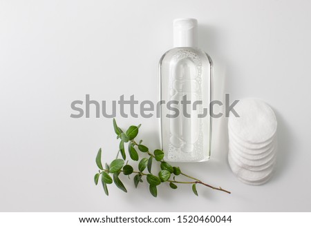 Micellar cleansing water and discs to remove cosmetics and cleanse the skin on grey. Copy space text Royalty-Free Stock Photo #1520460044