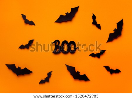 Terrifying Halloween background with bats flying on orange, boo text
